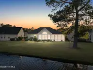 7568 Dunbar Drive SW, Sunset Beach, NC 28468 — 3-bedroom waterfront home in Sandpiper Bay, Sunset Beach, NC, photo 2 of 51: Back Twilight view