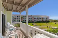 9201 Coast Guard Road A208, Emerald Isle, NC 28594 — 3-bedroom waterfront condo in Pebble Beach, Emerald Isle, NC, photo 8 of 45: Covered porch overlooking pool and ocean