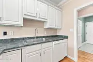 112 White Heron Lane, Swansboro, NC 28584 — 3-bedroom waterfront home in Bluewater Cove, Swansboro, NC, photo 13 of 60: another kitchen view sink