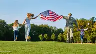 244 Maddox Drive, Aberdeen, NC 28315 — 3-bedroom home in Martin Farms, Aberdeen, NC, photo 21 of 25: Military Family Walking in Field Holding