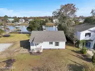 2502 E Yacht Drive, Oak Island, NC 28465 — 3-bedroom waterfront home in Tranquil Harbor, Oak Island, NC, photo 5 of 45: 08-Final Drone 2502 E Yacht Dr OKI-RJREM