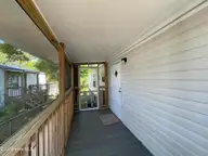 2807 Cross Bones Road SW, Supply, NC 28462 — 3-bedroom waterfront manufactured home in Buccaneer Hills, Supply, NC, photo 19 of 31: Screened Back Porch