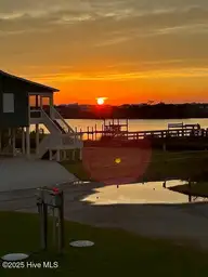 1914 Bird Lane, North Topsail Beach, NC 28460 — 2-bedroom waterfront home in Old Settlers Beach, North Topsail Beach, NC, photo 2 of 30: Sunset from porch taken 09-13-2025
