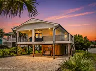 2508 E Beach Drive, Oak Island, NC 28465 — 3-bedroom waterfront home in Long Beach, Oak Island, NC, photo 1 of 62: DJI_20250809115038_0054_D-Edit_twilight_