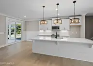 161 Twining Rose Lane, Holly Ridge, NC 28445 — 3-bedroom home in Summerhouse On Everett Bay, Holly Ridge, NC, photo 5 of 62: kitchen opens to screened-in porch