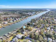 2502 E Yacht Drive, Oak Island, NC 28465 — 3-bedroom waterfront home in Tranquil Harbor, Oak Island, NC, photo 10 of 45: 02-Final Drone 2502 E Yacht Dr OKI-RJREM