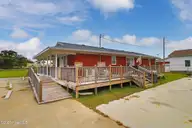 221 Bayview Drive, Harkers Island, NC 28531 — 2-bedroom waterfront home in Earl Davis, Harkers Island, NC, photo 7 of 53: Rear of Home with Wrap Around Porch