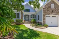 497 Broomsedge Court SE, Bolivia, NC 28422 — 4-bedroom waterfront home in Winding River Plantation, Bolivia, NC, photo 1 of 60: front of home and garage