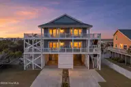6626 W Beach Drive, Oak Island, NC 28465 — 4-bedroom waterfront home in Kings Lynn, Oak Island, NC, photo 1 of 72: 6626WestBeachDriveTwilight-1
