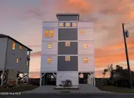 321 N New River Drive, Surf City, NC 28445 — 6-bedroom waterfront home, Surf City, NC, photo 1 of 73: 321NNewRiver_Front_Dusk_02