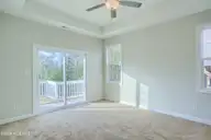 202 Broadleaf Drive, Jacksonville, NC 28546 — 4-bedroom waterfront home in Creekside at Aragona Village, Jacksonville, NC, photo 17 of 34: Primary Bedroom with Porch access
