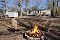 407 Maple Street SW, Shallotte, NC 28470 — 2-bedroom manufactured home in Lakewood Estates, Shallotte, NC, photo 1 of 26: Firepit and back yard